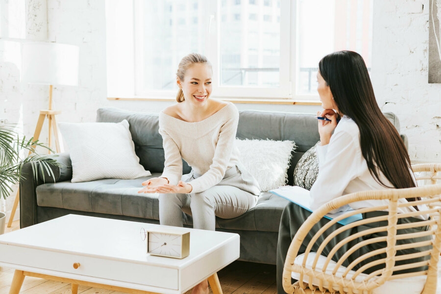 Zwei Frauen die sich unterhalten und eine Frau macht sich Notizen